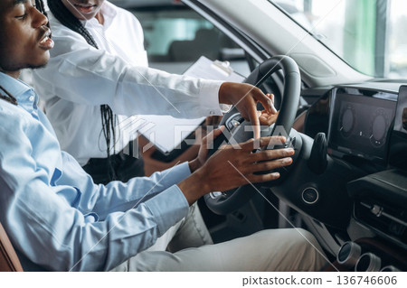 Trying the feel of vehicle. Man and woman are in the automobile Trying the feel of vehicle. Man and woman are in the automobile 136746606