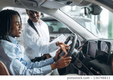 In brown colored seat, trying vehicle. Man and woman are in the automobile In brown colored seat, trying vehicle. Man and woman are in the automobile 136746611