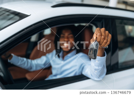 Window is opened, showing keys. Man in shirt is in the modern car Window is opened, showing keys. Man in shirt is in the modern car 136746679