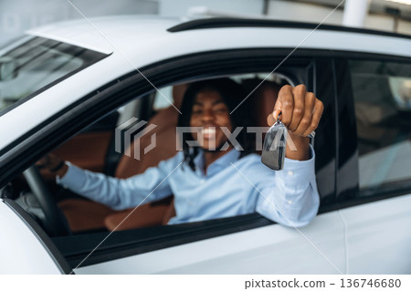 Window is opened, showing keys. Man in shirt is in the modern car Window is opened, showing keys. Man in shirt is in the modern car 136746680