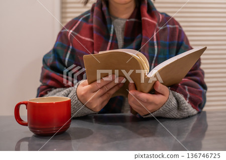 女人一邊喝熱咖啡一邊看書 136746725