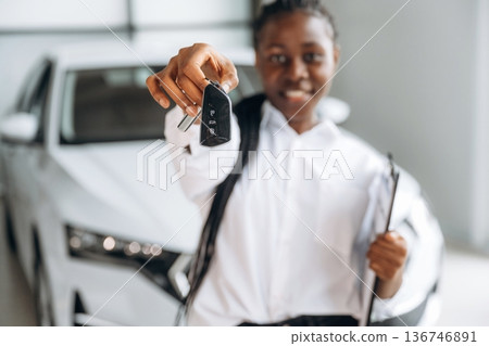 Cheerful, holding keys. Car seller, businesswoman is standing in automobile salon 136746891