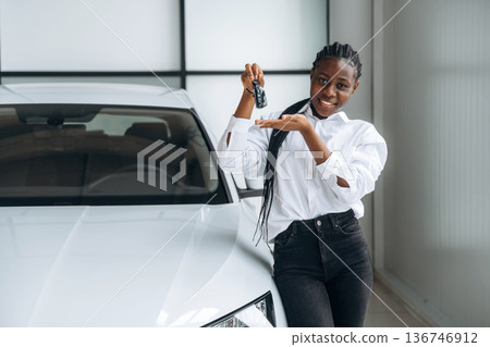 Car seller, businesswoman is standing in automobile salon Car seller, businesswoman is standing in automobile salon 136746912