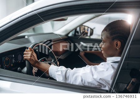 Formal white shirt, driving. Woman is in the modern car Formal white shirt, driving. Woman is in the modern car 136746931