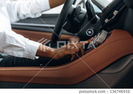 Pressing the button. Woman in white shirt is in the modern car Pressing the button. Woman in white shirt is in the modern car 136746938