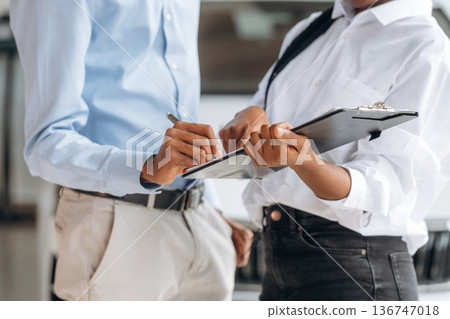 Man with woman are making business, signing documents, close up view Man with woman are making business, signing documents, close up view 136747018