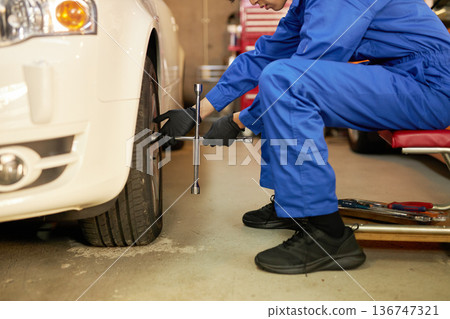 Auto mechanic changing tires at a factory 136747321