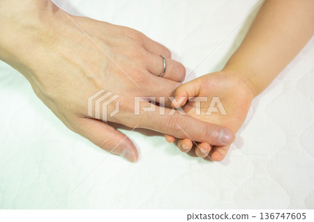 Parent's hand holding baby's hand Parent's hand holding baby's hand 136747605