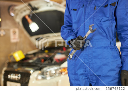 汽車修理工正在引擎蓋下修理。 汽車修理工正在引擎蓋下修理。 136748122