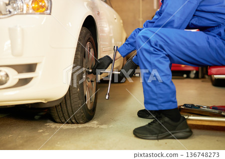 汽車修理工在工廠更換輪胎 汽車修理工在工廠更換輪胎 136748273