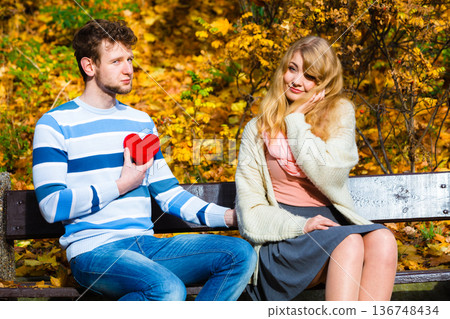 Man show feelings to girl in autumnal park. Man show feelings to girl in autumnal park. 136748434