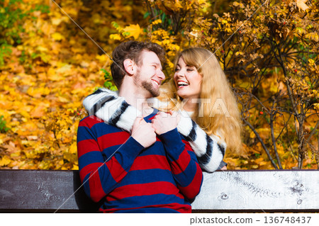 Lovers couple in autumn park on bench 136748437