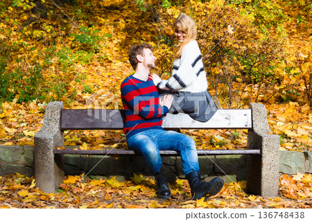 Lovers couple in autumn park on bench 136748438