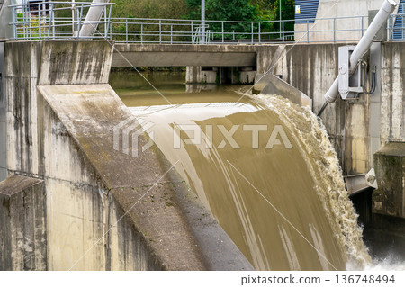 Discharge of water at the dam during flood. Powerful water flow Discharge of water at the dam during flood. Powerful water flow 136748494
