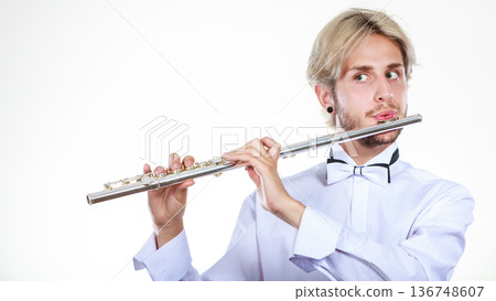 Male flutist playing his flute Male flutist playing his flute 136748607