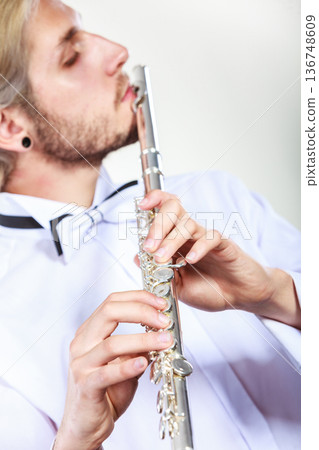 Male flutist playing his flute Male flutist playing his flute 136748609