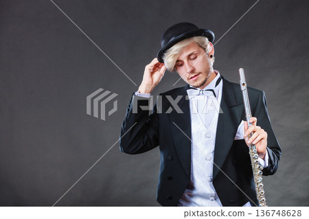 Elegantly dressed musician holding flute Elegantly dressed musician holding flute 136748628