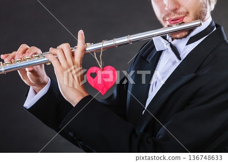 Male flutist with flute and heart. Love melody 136748633