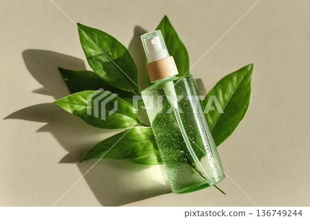 Transparent Cosmetic spray bottle and green leaf, natural light and shadow, dispenser with green liquid on beige. Natural Vegan skin care products, Eco-friendly Organic cosmetics concept, copyspace 136749244