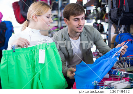 Married couple choosing summer shorts together in clothing store Married couple choosing summer shorts together in clothing store 136749422