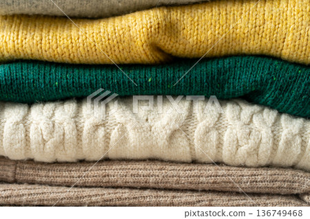A stack of knitted sweaters on the table. Background textures 136749468