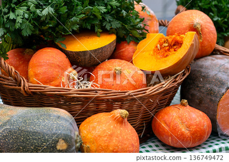 Many pumpkins lie in baskets and on a table for sale at the market 136749472