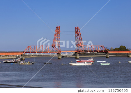 A view of the Chikugo River Lift Bridge and fishing boats on a sunny day A view of the Chikugo River Lift Bridge and fishing boats on a sunny day 136750495