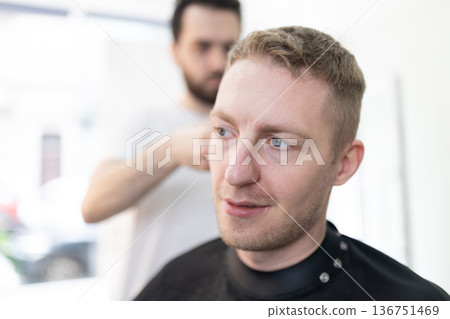 Client receiving professional haircut from skilled barber Client receiving professional haircut from skilled barber 136751469