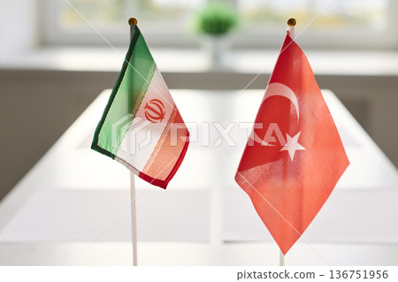 Iran and Turkey desk flags on conference table showing diplomacy and negotiations 136751956