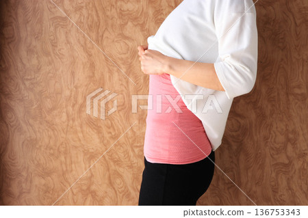 一個女人穿著肚皮作為抵禦寒冷的對策 溫暖的形象 136753343