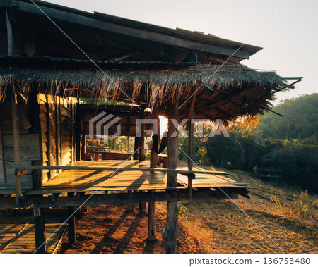 Traditional wooden stilt house in rural mountain farm during golden sunrise 136753480