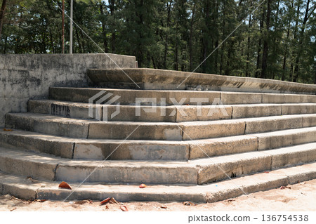 Weathered concrete steps set outdoors with tall trees in the background Weathered concrete steps set outdoors with tall trees in the background 136754538