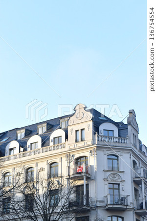 The facade of a classical building with a decorative balcony under the blue sky 136754554