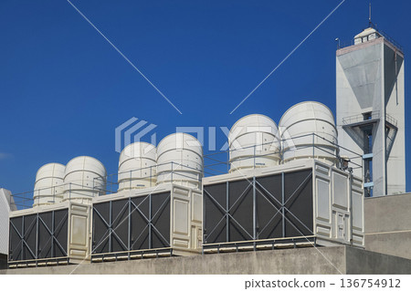 Large air conditioning compressor chiller unit on commercial building rooftop, HVAC cooling system equipment installation, industrial ventilation technology for climate control in urban architecture. Large air conditioning compressor chiller unit on commercial building rooftop, HVAC cooling system equipment installation, industrial ventilation technology for climate control in urban architecture. 136754912