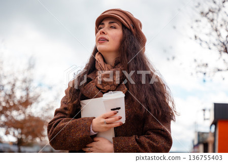 Bottom view of woman finds comfort in reading while seated in the open air of the city. Self-care and quiet education. Bottom view of woman finds comfort in reading while seated in the open air of the city. Self-care and quiet education. 136755403