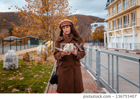 Elegant reader enjoys her book in the calm city. A perfect blend of weekend rest and intellectual pleasure. Elegant reader enjoys her book in the calm city. A perfect blend of weekend rest and intellectual pleasure. 136755407
