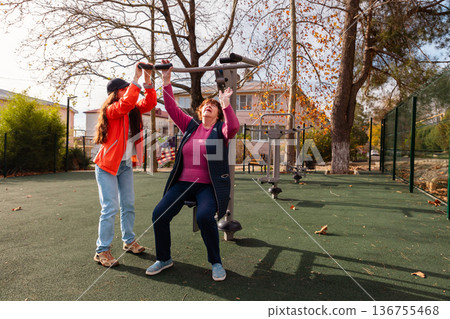 Senior woman following rehabilitation program with outdoor exercise after an operation. Sport supports recovery, vitality, and longevity in retirement. Senior woman following rehabilitation program with outdoor exercise after an operation. Sport supports recovery, vitality, and longevity in retirement. 136755468