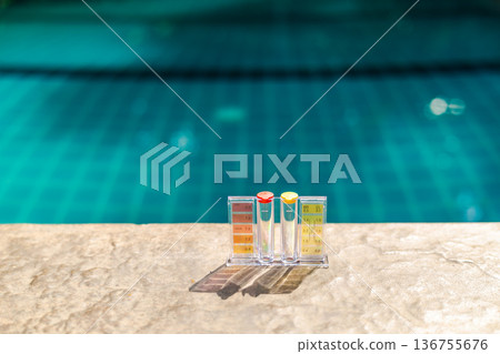 Pool water test kit with pH and chlorine scale on pool edge, swimming pool maintenance and water quality control concept with copy space and blue background Pool water test kit with pH and chlorine scale on pool edge, swimming pool maintenance and water quality control concept with copy space and blue background 136755676