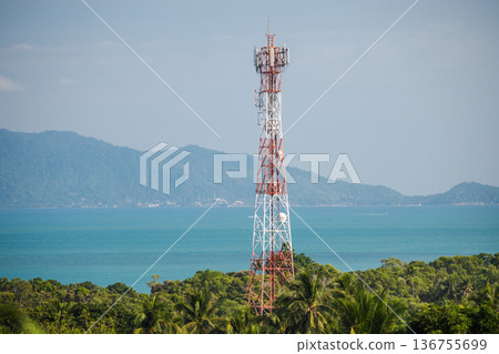 Telecommunication tower rising above tropical forest with turquoise sea and distant island hills under clear blue sky Telecommunication tower rising above tropical forest with turquoise sea and distant island hills under clear blue sky 136755699