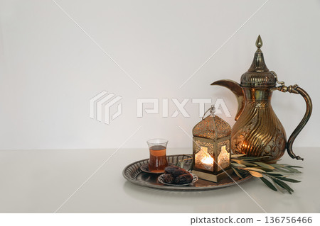 Arabic Coffee Pot Dallah, Turkish Tea Glass, Dates and Lantern on Silver Tray. Ramadan Kareem Islamic Still Life, Eid Hospitality. Traditional Middle East Iftar Decor. Glowing Metal Moroccan lantern. Arabic Coffee Pot Dallah, Turkish Tea Glass, Dates and Lantern on Silver Tray. Ramadan Kareem Islamic Still Life, Eid Hospitality. Traditional Middle East Iftar Decor. Glowing Metal Moroccan lantern. 136756466