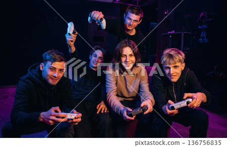 Focused and concentrated. Young gamers are with console controllers indoors Focused and concentrated. Young gamers are with console controllers indoors 136756835