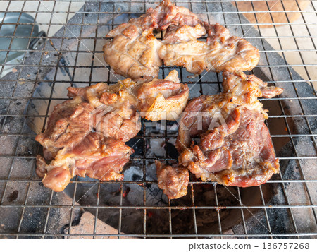 The marinated pork neck meat grilling on a traditional charcoal stove. 136757268