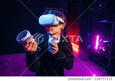 Young man is in virtual reality glasses indoors Young man is in virtual reality glasses indoors 136757313