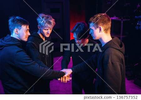 Gamers are standing in the dark room together Gamers are standing in the dark room together 136757352