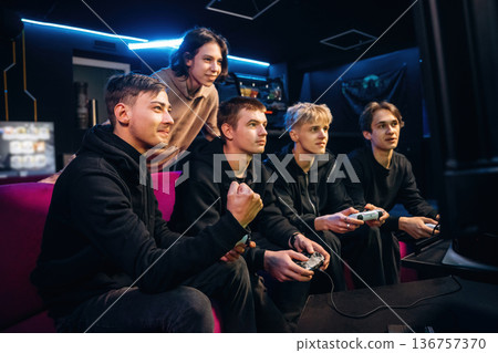 Victory, celebrating. Group of young gamers are indoors 136757370
