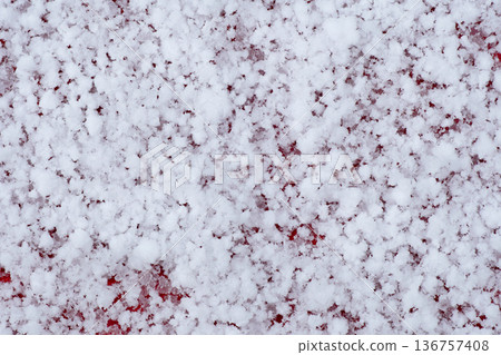 Abstract winter background with fine snowflakes covering a red surface. Variations of snow conditions available. 136757408