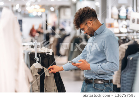 Big choice. Man customer is in the clothing store 136757593