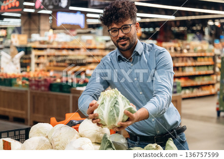 Front view. Man is in the grocery store Front view. Man is in the grocery store 136757599