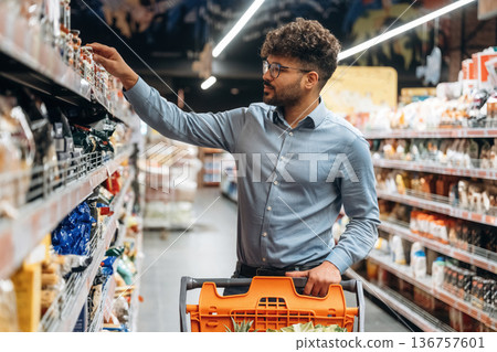 Taking the product. Man is in the grocery store Taking the product. Man is in the grocery store 136757601