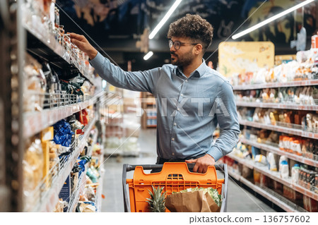 Taking the product. Man is in the grocery store 136757602